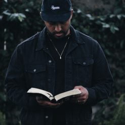 man in black jacket holding book